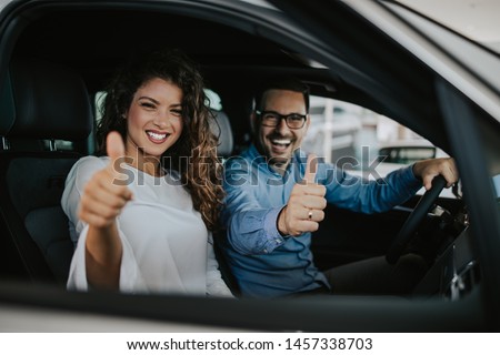 Happy middle age couple enjoying while choosing and buying new car at showroom. Royalty-Free Stock Photo #1457338703