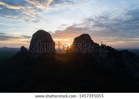 Landscape forest and mountain at sunset with twilight sky aerial view. Aerial View overlooking a green valley with a large mountain top.When the bats fly out of the cave to find work