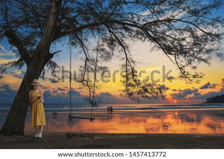 Young woman holding and using modern smart phone on the sunset,