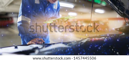 car service, repair, maintenance concept - Asian auto mechanic man or Smith writing to the clipboard at workshop warehouse, technician doing the checklist for repair machine a car in the garage,banner