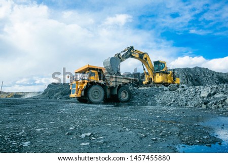 Work of trucks and the excavator in an open pit on gold mining, soft focus Royalty-Free Stock Photo #1457455880