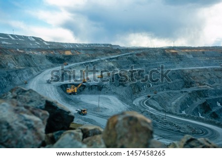 Work of trucks and the excavator in an open pit on gold mining, soft focus Royalty-Free Stock Photo #1457458265