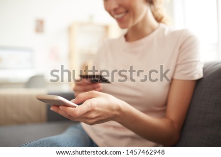 Close-up of positive woman using smartphone to link credit card to mobile wallet, she adding card number Royalty-Free Stock Photo #1457462948