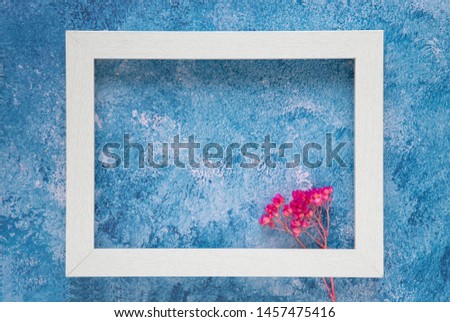 A white wooden frame mock up template on blue acrylic background