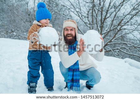 Happy father and son play on winter Christmas time. Happy smiling family on sunny winter day. Concept of friendly family