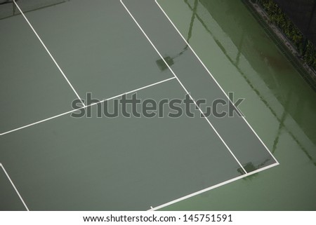 The tennis court is very empty after rain