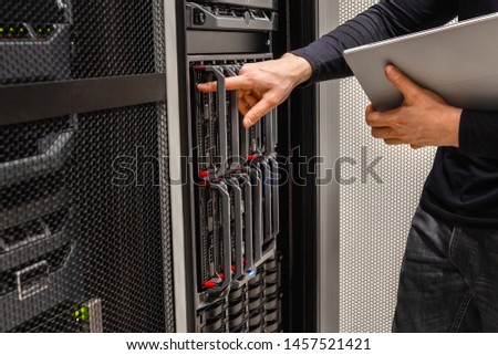 IT Professional Holding Digital Tablet Checking Blade Servers in Datacenter