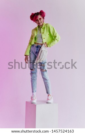 woman in stylish clothes standing on a cube