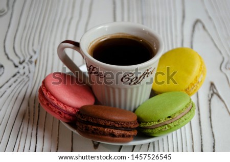 Macarons chocolate raspberry cookies with lemon and pistachios with a cup of coffee
on white background close up