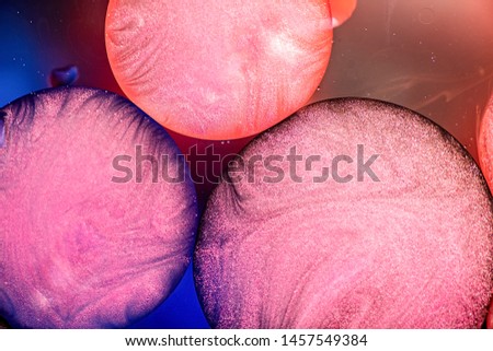 Abstract background. Pink oil bubbles on dark water background