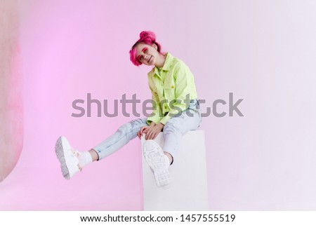 woman sitting on a neon cube studio