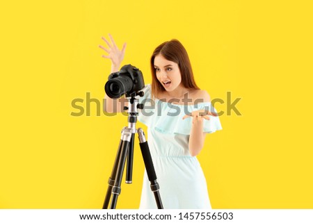 Displeased female photographer on color background