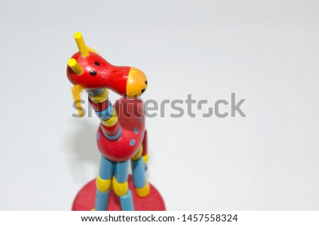 red and blue cute wooden giraffe kid's toy on white background with space for texts or article