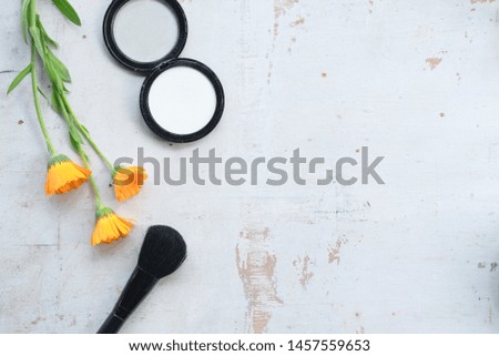 Face powder and make up brush on a white wooden table flat lay background with copy space.