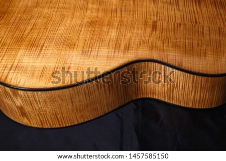 wood texture of lower deck of six strings acoustic guitar on black background