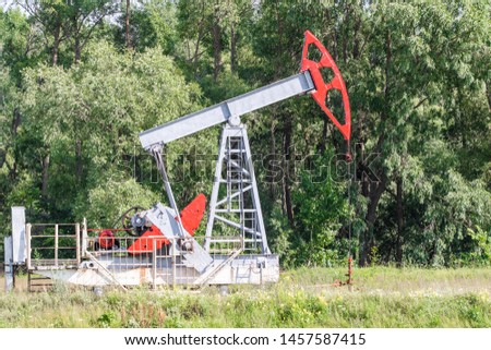 Oil pump. Oil industry equipment. Nature landscape summer.