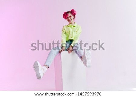 woman in jeans sits on neon cube retro fashion
