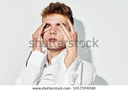crossdresser holds fingers on his face on an isolated background