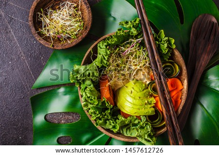 Healthy vegan lunch in a coconut bowl. Buddha bowl on a dark background. Royalty-Free Stock Photo #1457612726