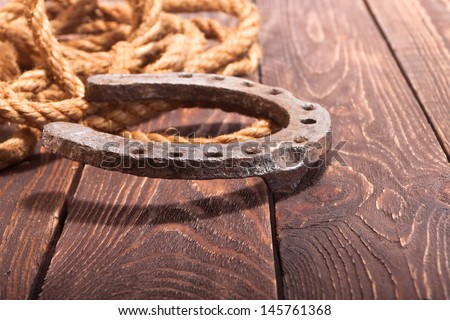 Horseshoe with a rope on a wooden floor