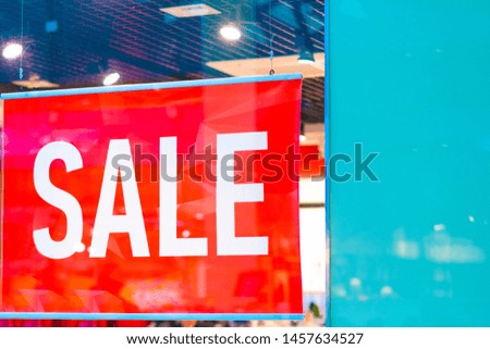Sale sign in a fashion clothes shop display window 