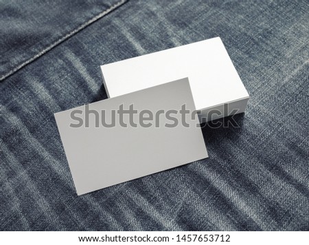 Photo of blank white name cards on denim background. Business cards template.