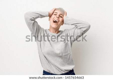 Young curvy caucasian woman isolated on white background laughs joyfully keeping hands on head. Happiness concept.