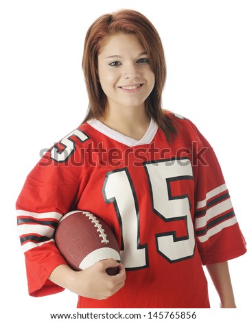 A waist-up image of a beautiful teen girl in an over-sized red jersey.  She's clutching a football.  On a white background.