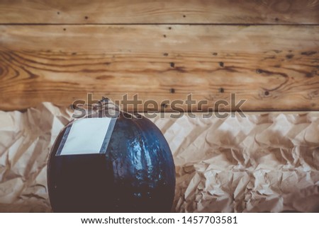 A big black pumpkin with an empty white tag. Autumn pumpkin decorated with sale tag. Fall, Halloween and Thanksgiving concept. Copy space