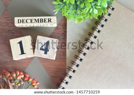 December 14. Date of December month. Number Cube with a flower and notebook on Diamond wood table for the background.