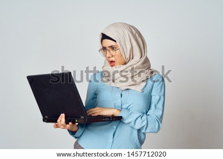 a woman in a veil holding a laptop in her hand                               