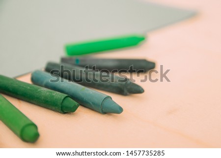 
Wax crayons in shades of green on the table