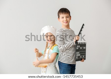Little chef and film director on white background