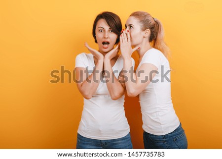 Blonde woman say a secret to her brunette friend. Wonder emotion on the face . - Image