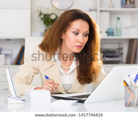Young office woman is working with project behind laptop in the office.