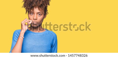 Beautiful young african american woman over isolated background mouth and lips shut as zip with fingers. Secret and silent, taboo talking