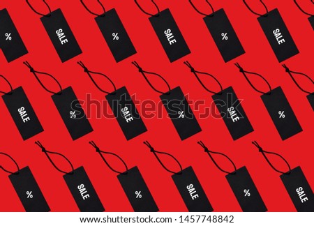 Top view of black sale tags with Sale inscription and percent sign on red background. Flat lay.