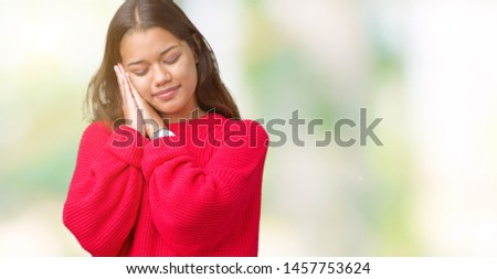 Young beautiful brunette woman wearing red winter sweater over isolated background sleeping tired dreaming and posing with hands together while smiling with closed eyes.
