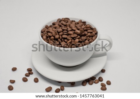 Coffee beans in cup and isolated on white background
