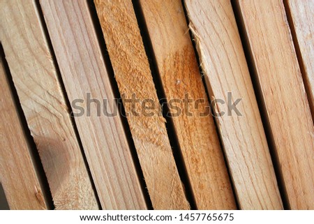 Warehouse of new wooden boards at the sawmill. Wood construction material. Smooth dried boards are neatly folded. Close-up photo. For business card or banner.