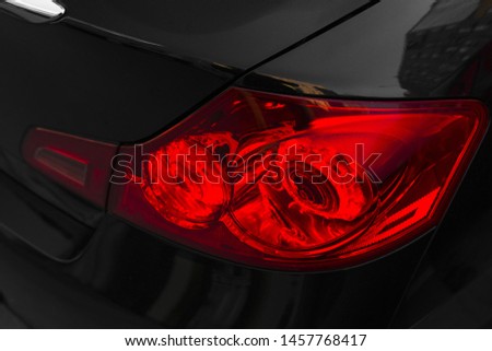 Back of black car with red rear light