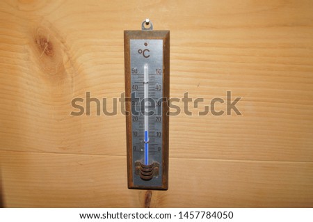 Storm weather concept. Air temperature,vintage analog thermometer isolated on wooden background.