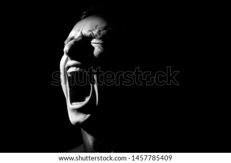 black and white photo on a black background, distorted face screaming Royalty-Free Stock Photo #1457785409