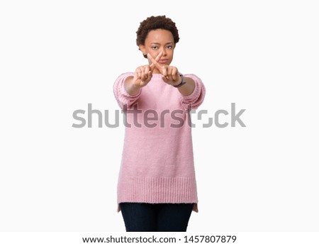 Beautiful young african american woman over isolated background Rejection expression crossing fingers doing negative sign