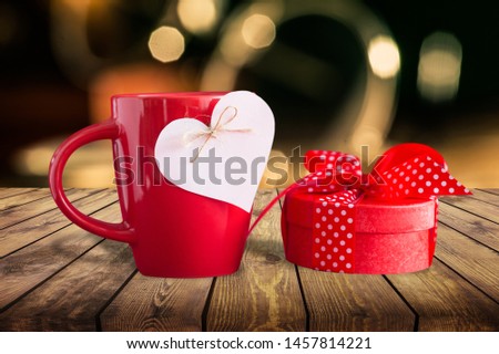 &quot;With love&quot; message on red polka dot mug and red gift with polka dot ribbon bow against a red background for a bright, fun and cheerful Valentines Day, Christmas, birthday or Mothers Day