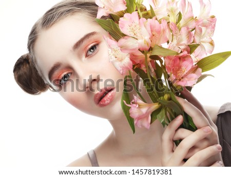beauty and fashion concept: teenager female model with perfect make up and pink flowers