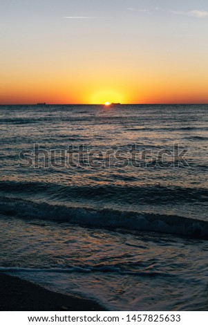 Beautiful sea waves foam closeup and red sky with sun in sunrise light on tropical island. Waves in ocean at sunset. Tranquil calm moment. Summer vacation. Copy space