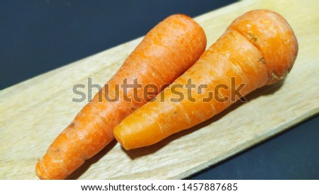 fresh carrots on a wooden mat with a black background