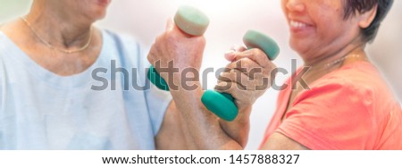 Healthy strong senior old people holding dumbells for doing exercise or physical therapy in nursing home Royalty-Free Stock Photo #1457888327