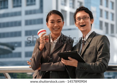 Businessman and business woman using tablet working together on new project in modern city background. Business people meeting -colleagues discussion, talking and sharing ideas.